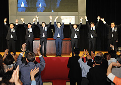 会場の声援に手を振って応える山口代表（中央）と国重氏ら＝17日　大阪市